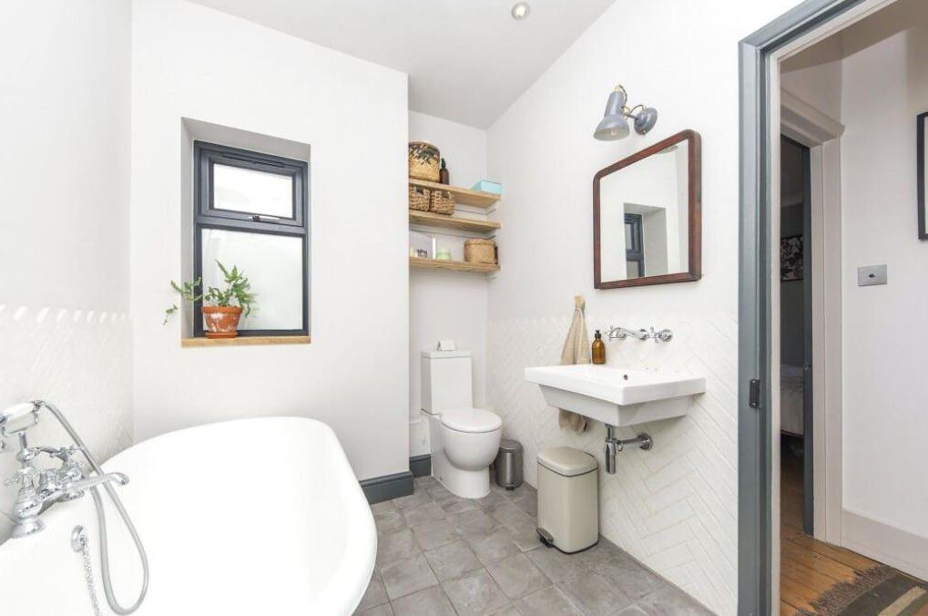 After — bathroom with roll-top bath and wall-hung sink